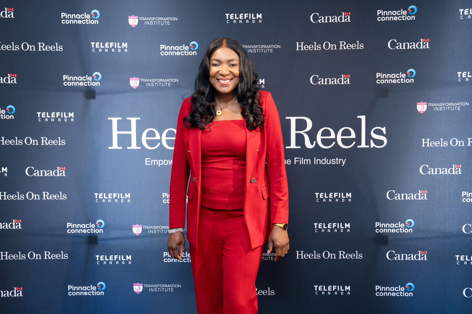 A director photographed at the Heels On Reels media backdrop